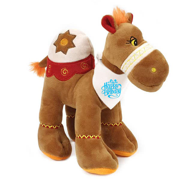 Charming brown camel plush, 25cm tall, wearing a blue "Happy Birthday" bandana. Super soft and huggable with recycled filling.