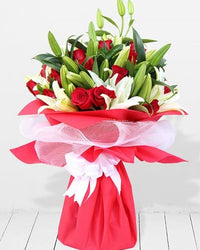 Breathtaking arrangement of 20 white lilies and 15 deep red roses, symbolizing purity and love.