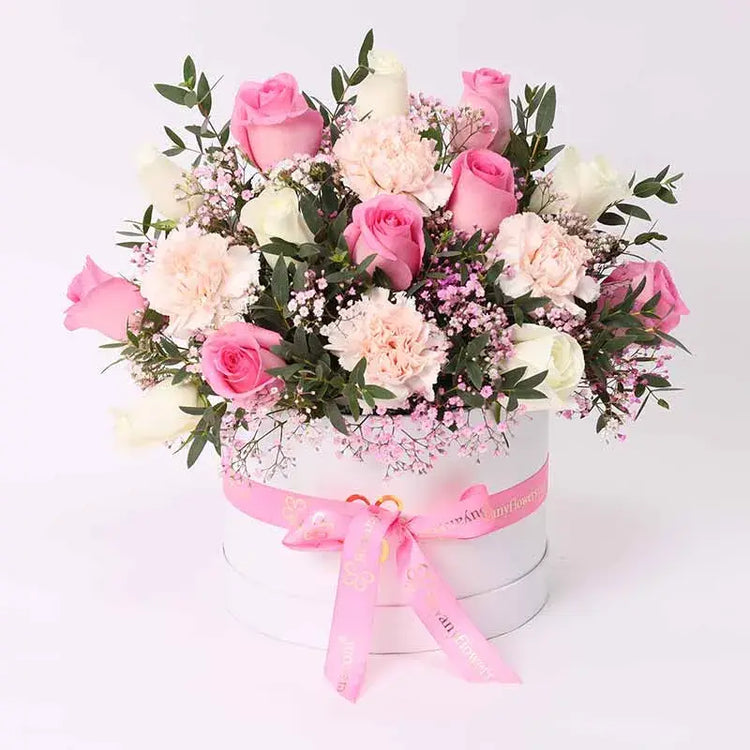 Enchanted Elegance: Pink & White Floral Basket": Showcase a beautifully arranged basket overflowing with 7 soft pink roses, 6 pristine white roses, and 4 delicate pink carnations.