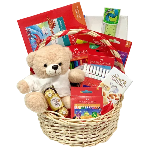 Kids' art gift set in a wicker basket with Faber-Castell colors, a sketch pad, and a teddy.