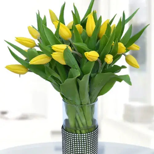 Bunch of bright yellow tulips in a vase. Perfect gift to brighten someone's day in UAE.