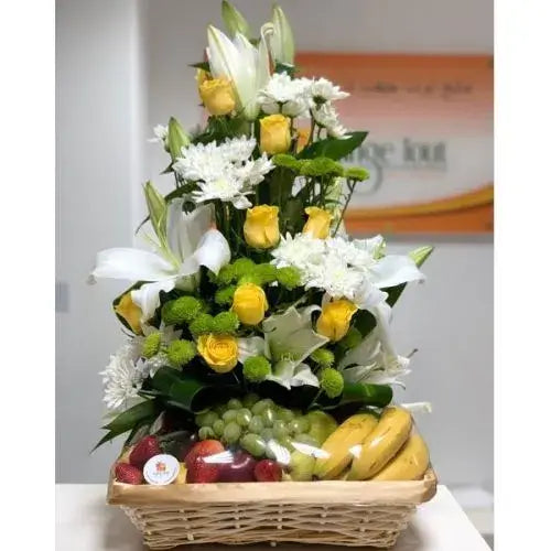 Wicker basket with colorful fruits and bright flowers (lilies, roses, chrysanthemums).