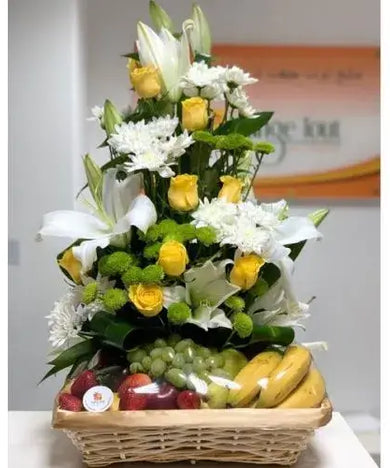 Wicker basket with colorful fruits and bright flowers (lilies, roses, chrysanthemums).