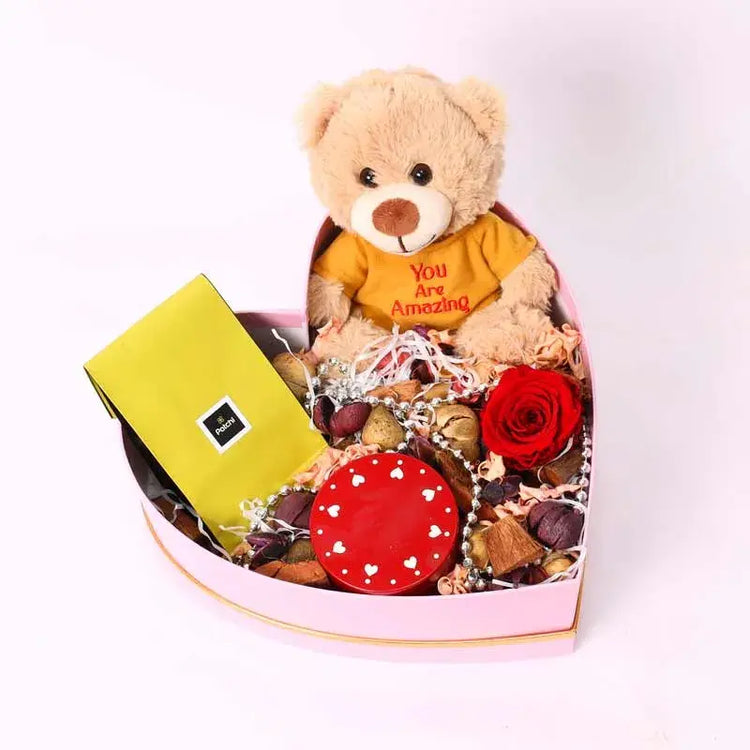 Preserved red rose, Patchi chocolates, love-scented candle, "You Are Amazing" teddy bear in heart box.