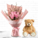 Person gifting the bouquet and teddy bear to a loved one, expressing affection on an anniversary or romantic occasion.
