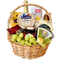 A photo of a wicker gift basket overflowing with a variety of cheeses, grapes, nuts, crackers, a jar of chutney, a bottle of sparkling grape juice, and small hazelnut snacks.