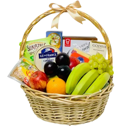 A photo of a wicker gift basket overflowing with colorful fruits, gourmet cheese wedges, a chocolate bar, and various crackers.