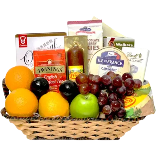 A photo of a wicker keepsake basket overflowing with cheese wedges, crackers, cookies, a tea box, and a "Get Well Soon" foil balloon.