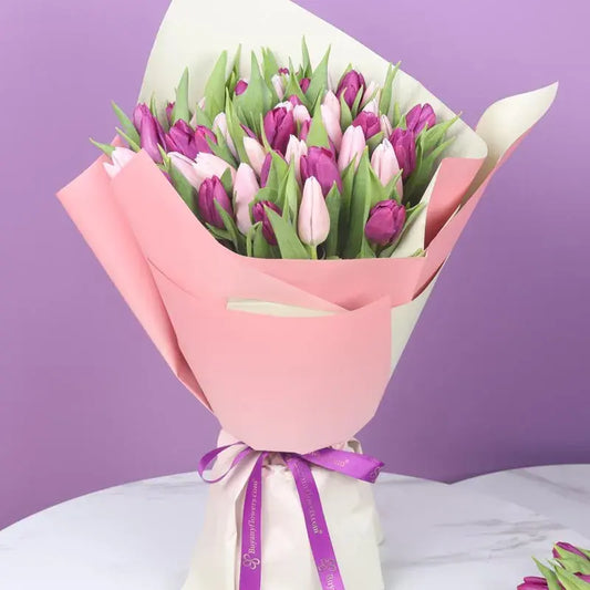 A stunning bouquet featuring 26 vibrant purple tulips and 25 charming pink tulips, beautifully wrapped in dual-colored paper.