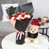 Couple holding the bouquet and teddy, expressing love and affection.