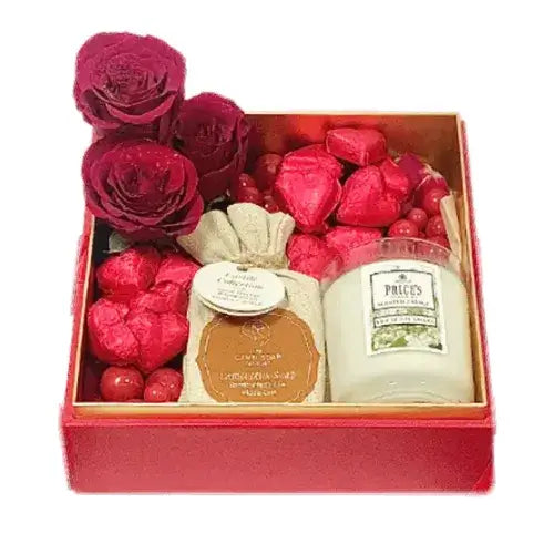 Luxury gift box with red roses, camel milk soap, chocolates, and a candle. Tied with ribbons in an acrylic box (Romantic Gift Dubai).