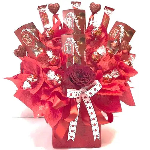  Red box with cellophane wrapping and ribbon containing Lindt chocolates and a single red rose