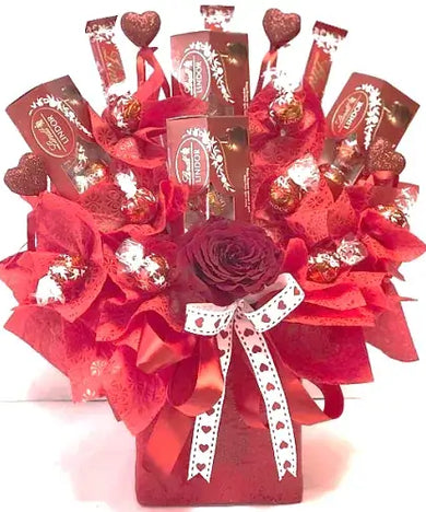  Red box with cellophane wrapping and ribbon containing Lindt chocolates and a single red rose