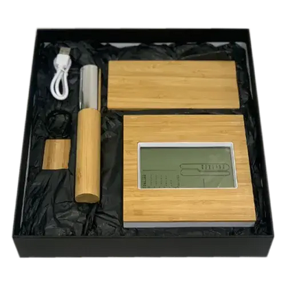 Black gift box containing bamboo wireless power bank, desk clock, pen with case, and metal keychain.