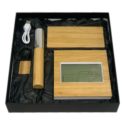 Black gift box containing bamboo wireless power bank, desk clock, pen with case, and metal keychain.