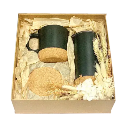 Cardboard gift box containing black mugs with lids, black tumbler with cork bottom, and cork coaster.