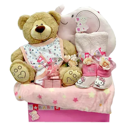 Photo of a gift set with baby essentials (blanket, towel, bib, romper, pillow) in pink, blue, or neutral colors, a soft toy, chocolates, and decorative stickers