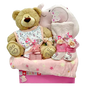 Photo of a gift set with baby essentials (blanket, towel, bib, romper, pillow) in pink, blue, or neutral colors, a soft toy, chocolates, and decorative stickers