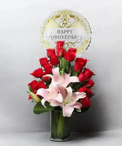 Celebrate your anniversary in style! Red roses, lilies, balloon & vase, delivered fresh across UAE.