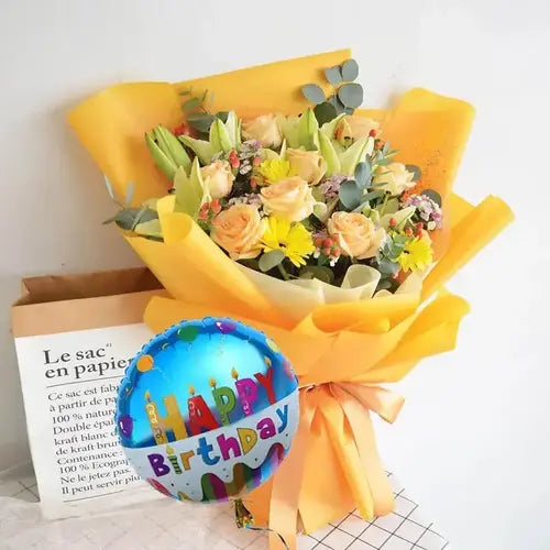 Birthday bouquet with peach roses, yellow gerberas, lilies, balloon & gift wrap. Dubai flower delivery (UAE).