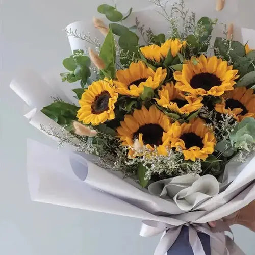 Sunflower bouquet with leaves and fillers, hand-tied with ribbon. Dubai flower delivery (UAE)