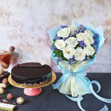 Photo of a beautiful gift set featuring a bouquet of white roses and blue statice paired with a delicious fudge cake, all wrapped in sky blue and off-white packaging