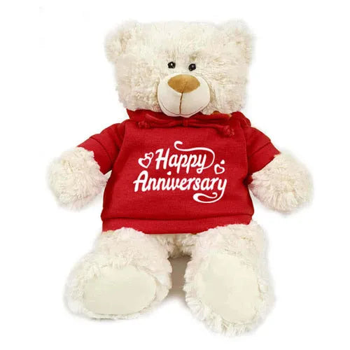 A soft, cream-colored teddy bear wearing a white "Happy Anniversary" hoodie. (Happy Anniversary Cream Bear - giftshop.ae)