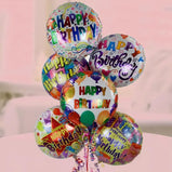 A bunch of 6 colorful Happy Birthday foil balloons filled with helium and tied with ribbons.