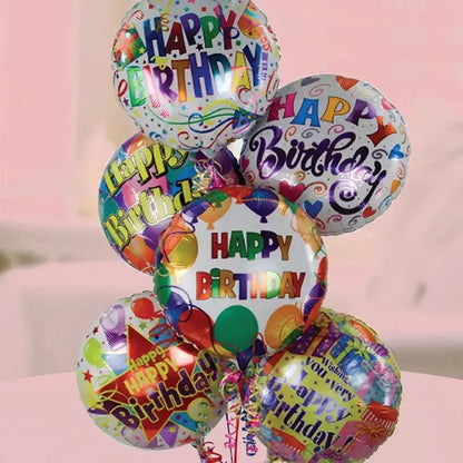 A bunch of 6 colorful Happy Birthday foil balloons filled with helium and tied with ribbons.