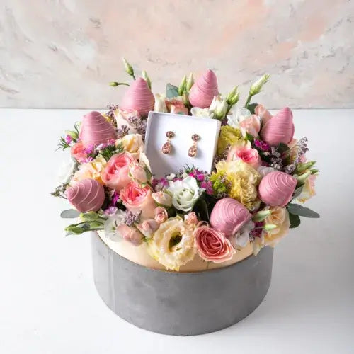 Luxury gifts for her in Dubai, featuring classic drop earrings and pastel flower arrangement