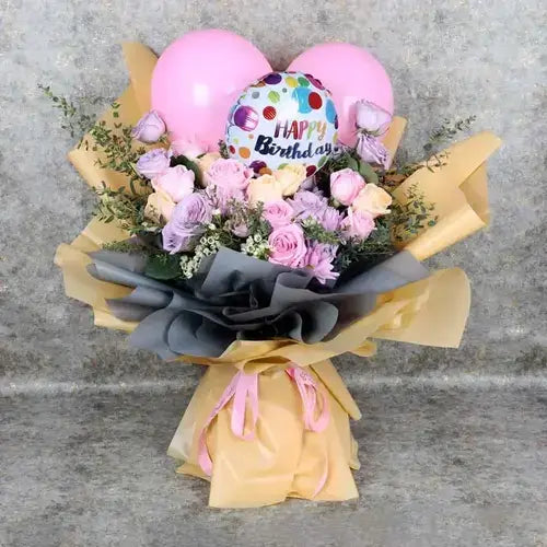 Birthday bouquet with pink and purple roses, balloons, and gift wrap. Dubai flower delivery (UAE).