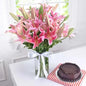 Fresh pink lilies bouquet in Dubai with seasonal leaves and a glass vase, available at Giftshop.ae