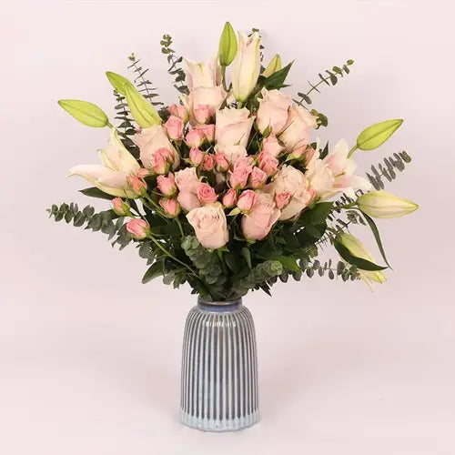 Pink lily and rose bouquet with baby blue eucalyptus in a blue vase. Dubai delivery (UAE)