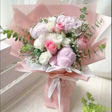 Pastel bouquet with pink peonies, white and pink roses, baby white rose, eucalyptus, and white limonium, beautifully wrapped with ribbon.