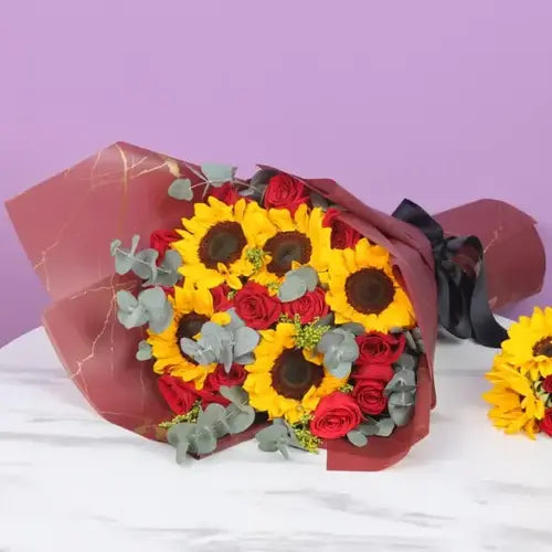 Sunrise romance flower bouquet wrapped in red and golden marble wrapping, tied with a black ribbon